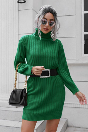 Green ribbed turtleneck mini dress with long sleeves and a black jeweled belt.