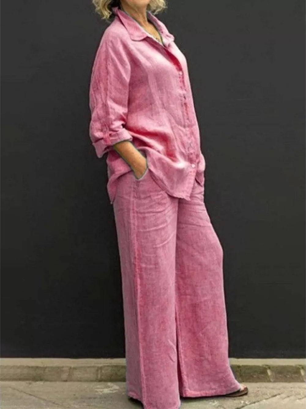 Pink button-down collared two-piece set with wide-leg pants and cuffed sleeves.