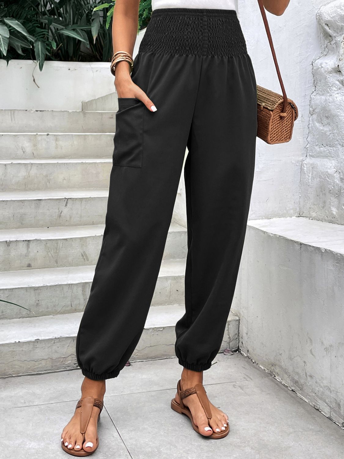 Black relaxed-fit cargo pants with smocked waist and cuffed ankles.