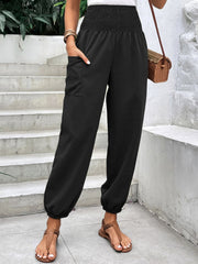 Black relaxed-fit cargo pants with smocked waist and cuffed ankles.