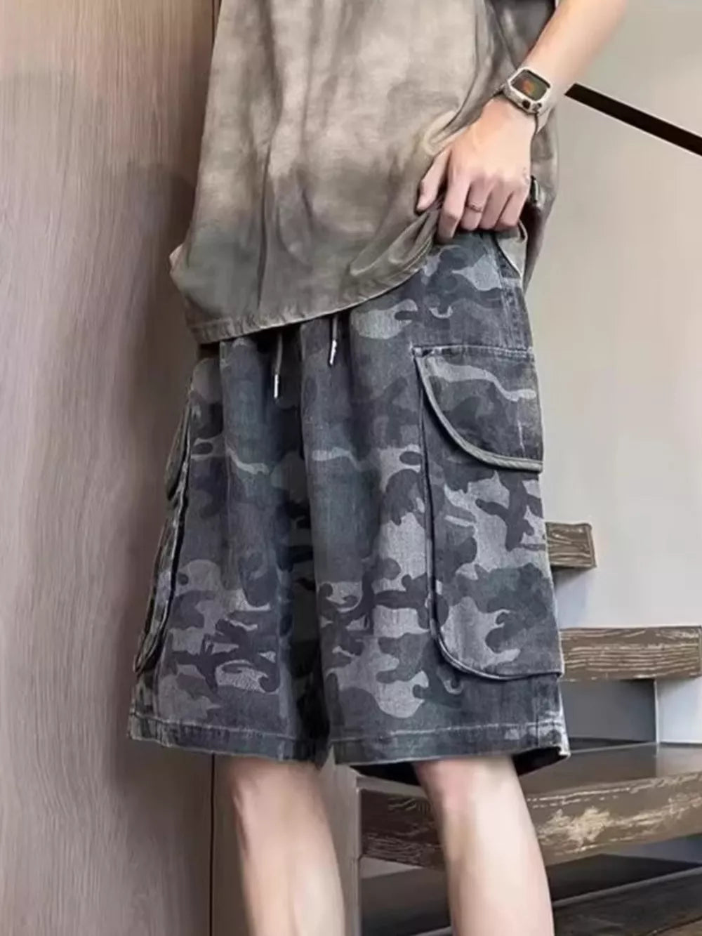 Relaxed fit black camo cargo shorts with multiple flap pockets and drawstring waist.