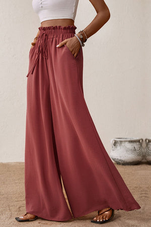 Crimson palazzo trousers with paperbag waist, drawstring, and pockets.