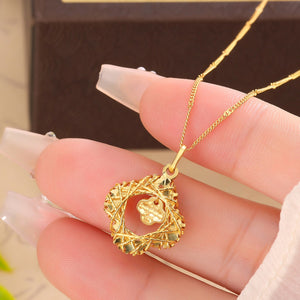 Gold clover pendant necklace with intricate woven design.