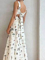 Sleeveless maxi dress with vacation print, tie-back detail, and pockets.