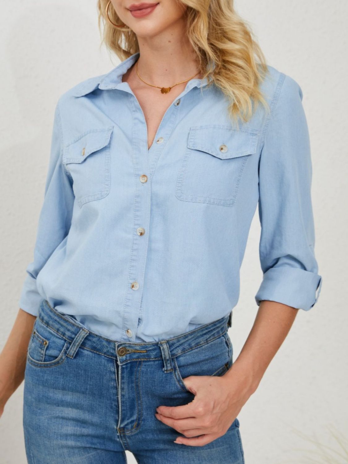 Light wash denim utility shirt with button front and chest pockets, styled with jeans.