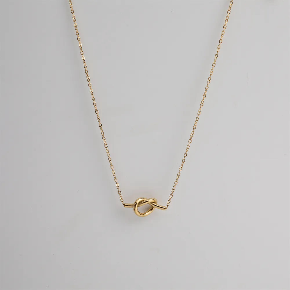 Gold knot pendant necklace with delicate chain, 18K gold-plated.