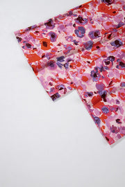 Painterly floral palazzo trousers in strawberry pink with wide legs and a colorful abstract bloom pattern.