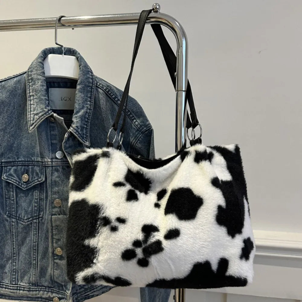 Cowhide print faux fur shopper bag with black straps and silver hardware.