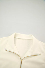 Cream cotton zip blouse with stand-up collar and ruffled detail