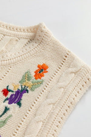 Beige cable knit vest with floral embroidery and open knit details.