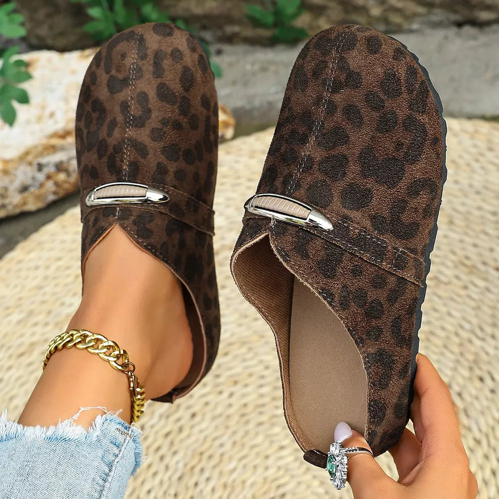 Brown leopard print slip-on flats with decorative buckle detail and side cutouts.