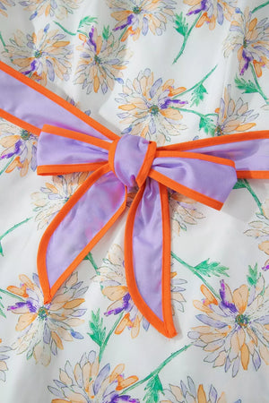 Floral print belted dress with purple bow detail and orange trim