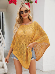 Mustard open-knit poncho top with asymmetric hem and boat neckline, styled with denim shorts.