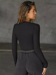 Black long-sleeve top with deep V-neck and cutout detail.
