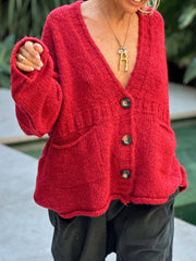 Deep Red textured bouclé oversized button-down cardigan with pockets and dark buttons.