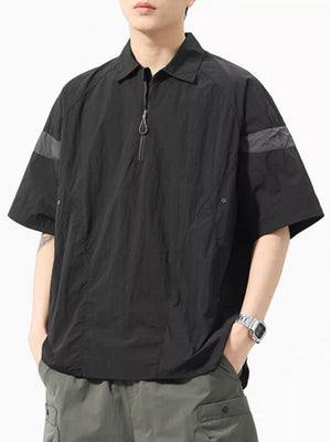 Black quarter-zip polo shirt with short sleeves and a chest pocket.
