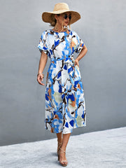 Blue abstract print midi dress with tie waist and short sleeves.