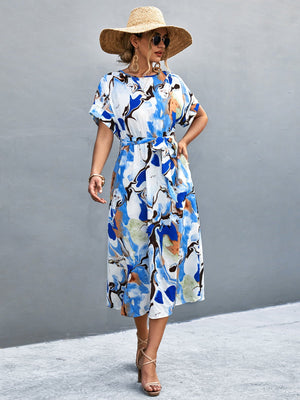 Blue abstract print midi dress with tie waist and short sleeves.