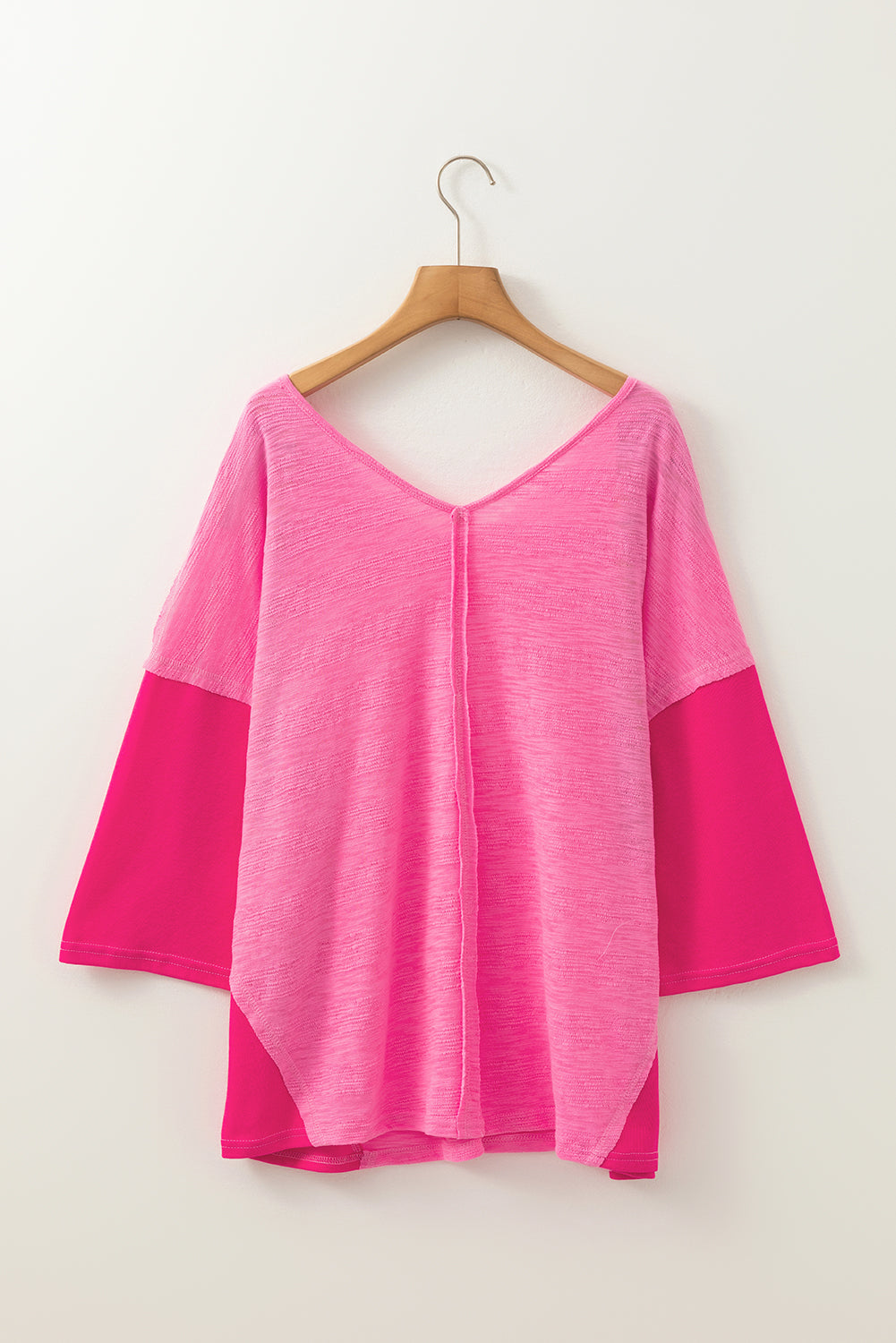 Hot pink V-neck blouse with contrast sleeves and textured front panel