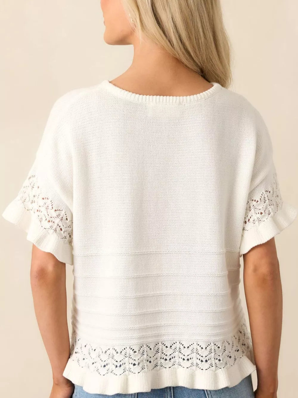White knit top with crew neck, short sleeves, and delicate lace trim at hem and cuffs.