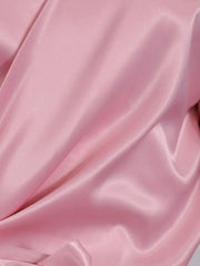 Blush pink satin blouse with draped detail and brooch.