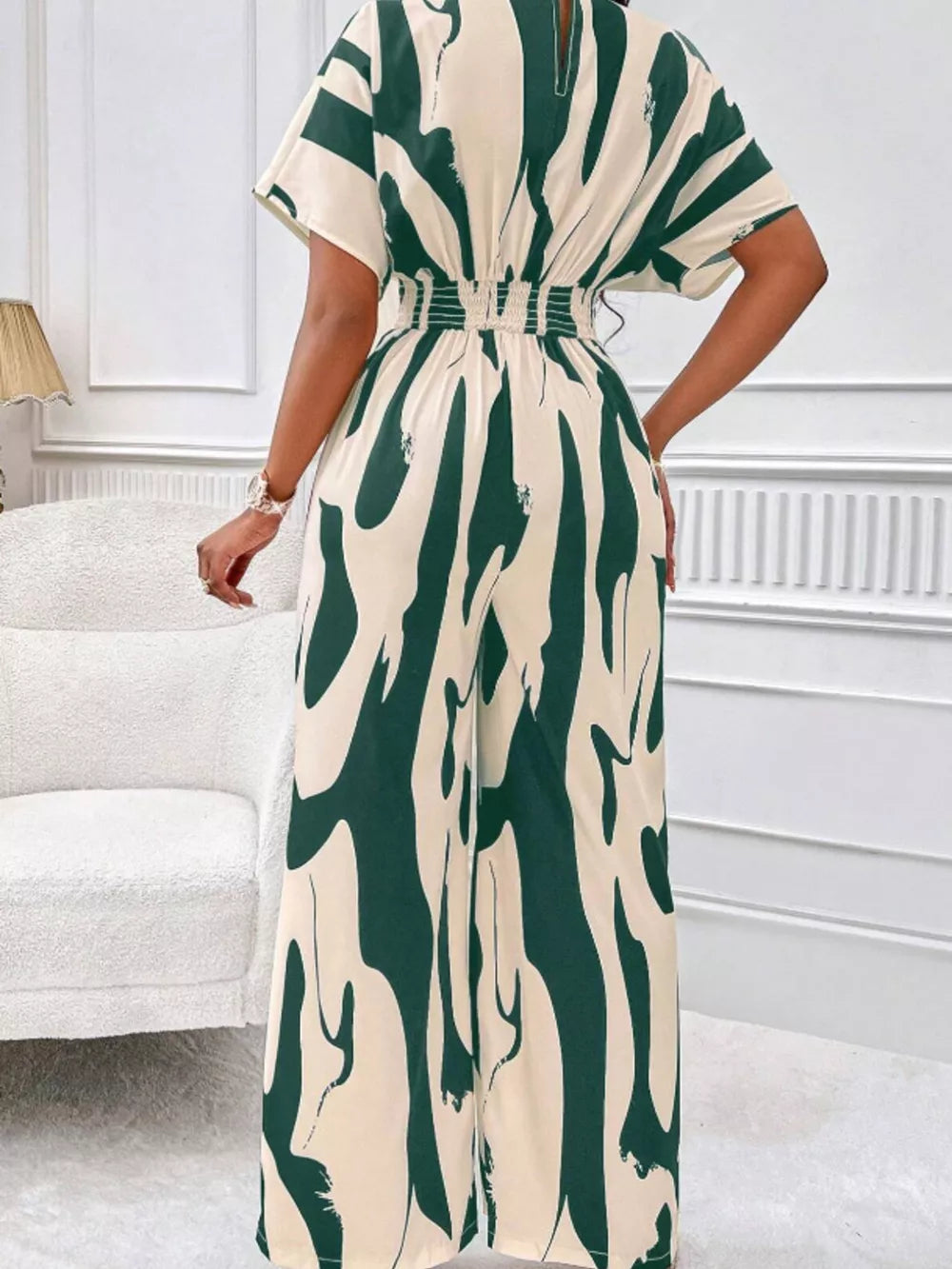 Chic abstract print wide-leg romper in green and cream with short sleeves and smocked waist.