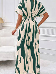 Chic abstract print wide-leg romper in green and cream with short sleeves and smocked waist.