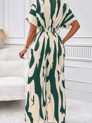 Chic abstract print wide-leg romper in green and cream with short sleeves and smocked waist.
