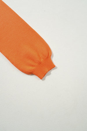 Orange knit sweater sleeve with ribbed cuff detail