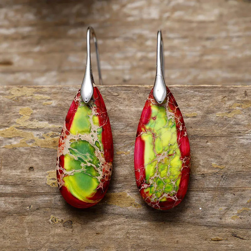 Marbled teardrop earrings with red, green, and gold gemstone patterns and silver hooks.