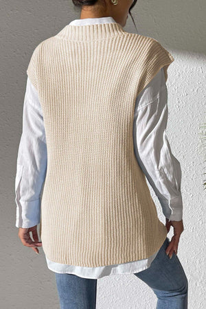 Beige textured knit V-neck sleeveless top with ribbed detail, styled over a white shirt.