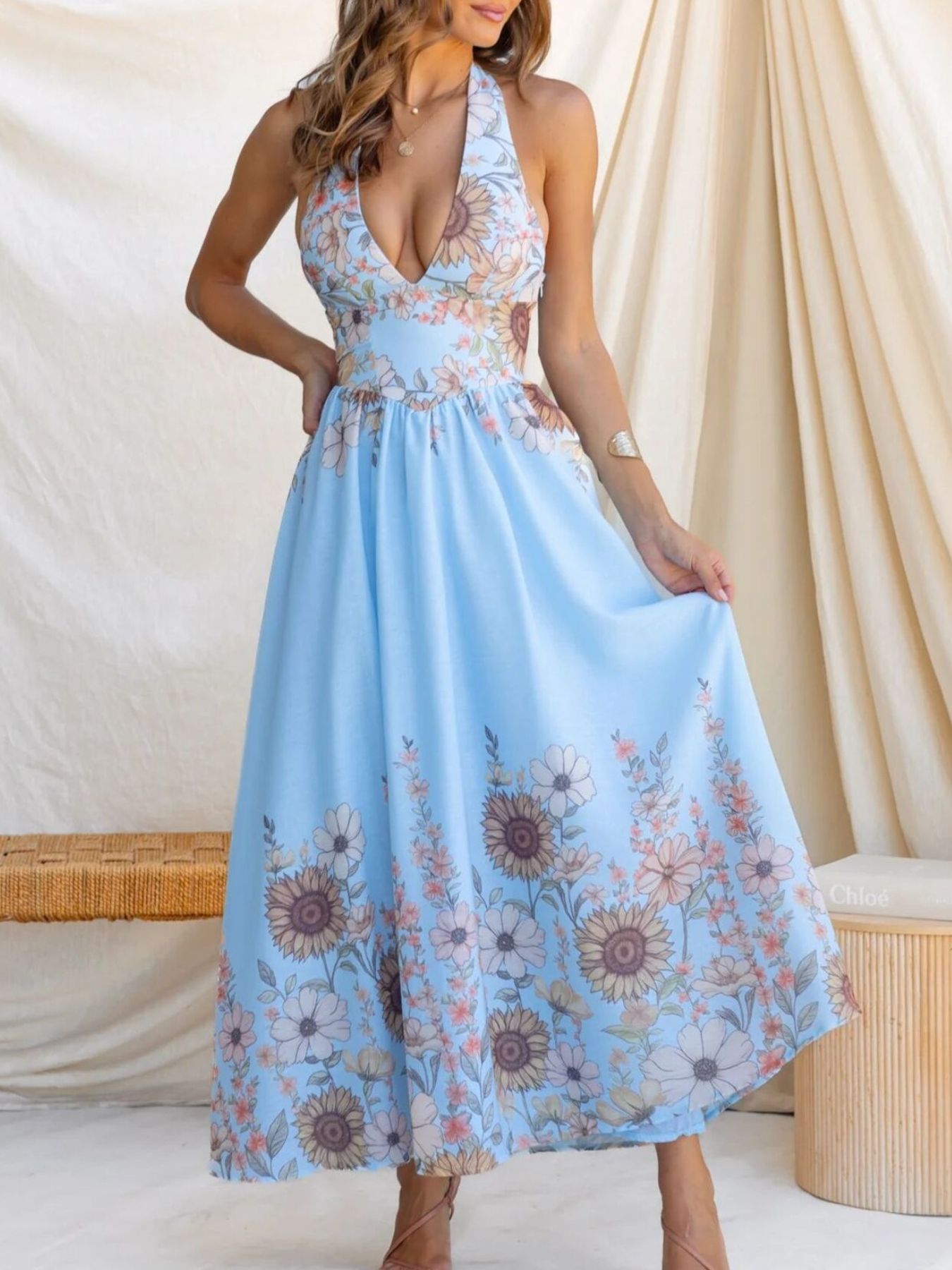 Blue floral halter neck maxi dress with a deep V-neck and flowing skirt.