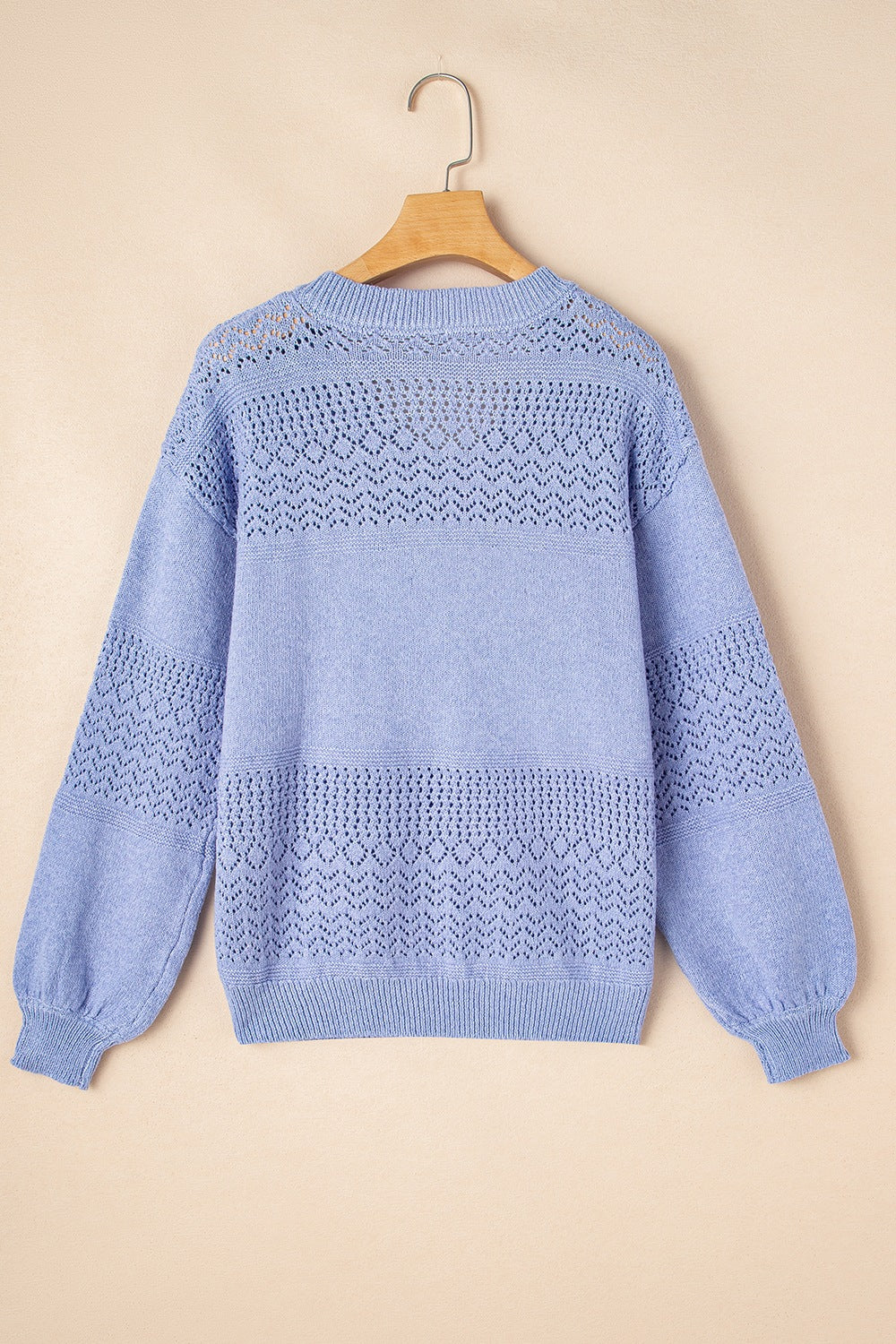 Light blue perforated knit V-neck pullover sweater with textured details.