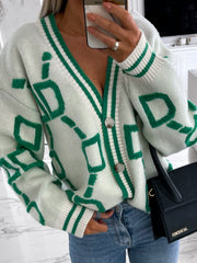 White acrylic cardigan with green geometric chain pattern, V-neck, button front, and striped trim.