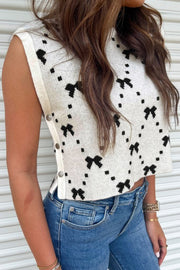 White knit tank sweater with black bow pattern and snap details on the side.