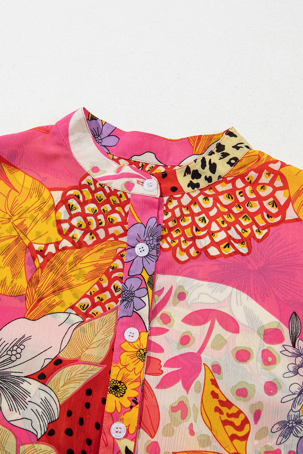 Patchwork floral print blouse in strawberry pink with a band collar and button front.