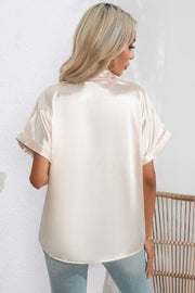 Ivory satin blouse with cuffed short sleeves and a button-down front, shown from the back.