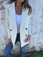 Ivory double-breasted blazer with sculpted lapels and dark buttons, styled with a white tank and jeans.