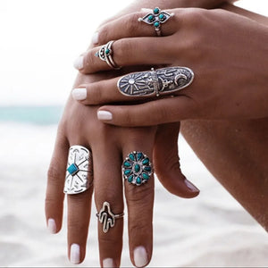 Bohemian silver rings with turquoise stones, including a sun & moon design and a shield shape.