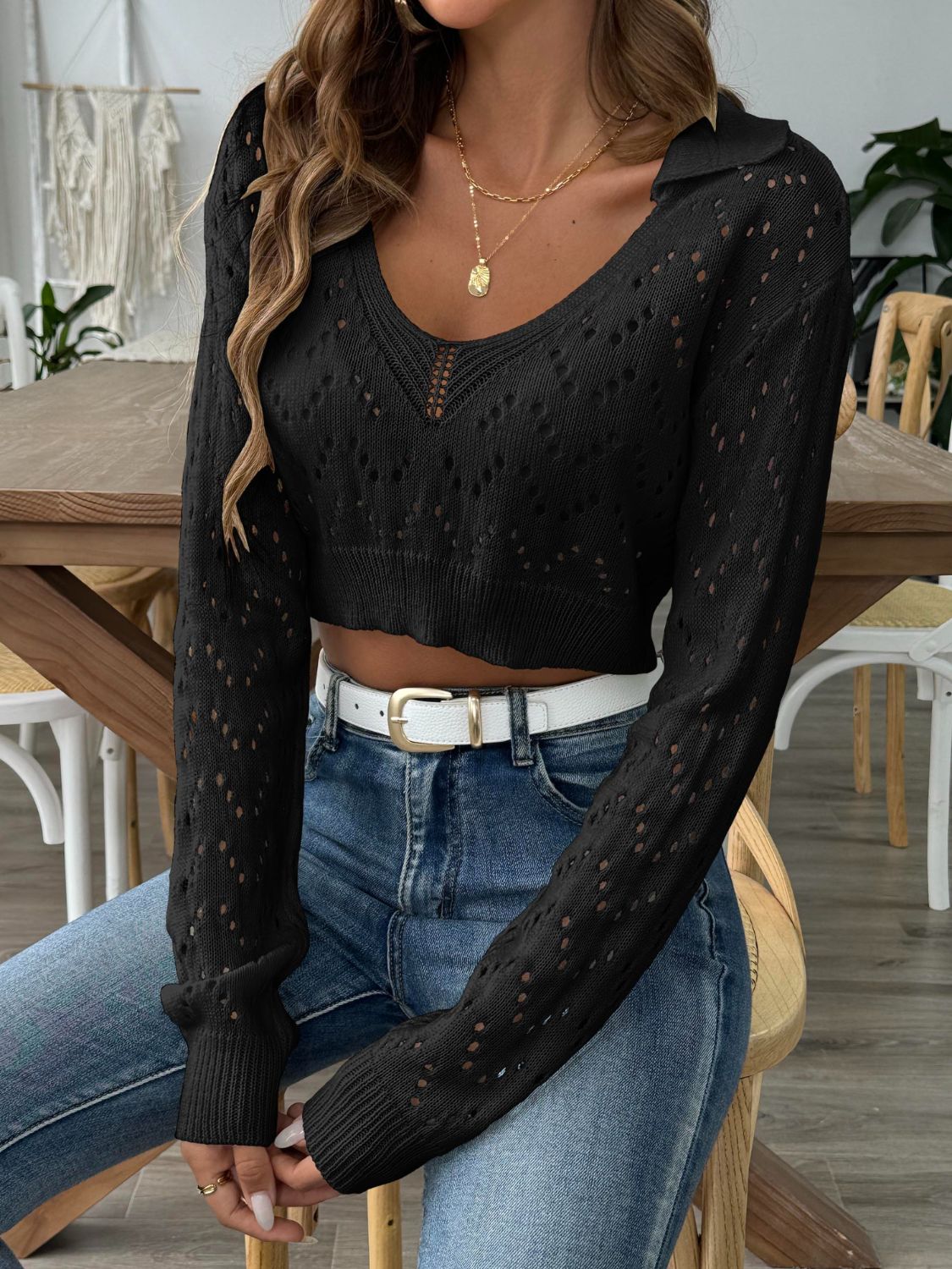 Black cropped pointelle knit polo top with V-neck and long sleeves.