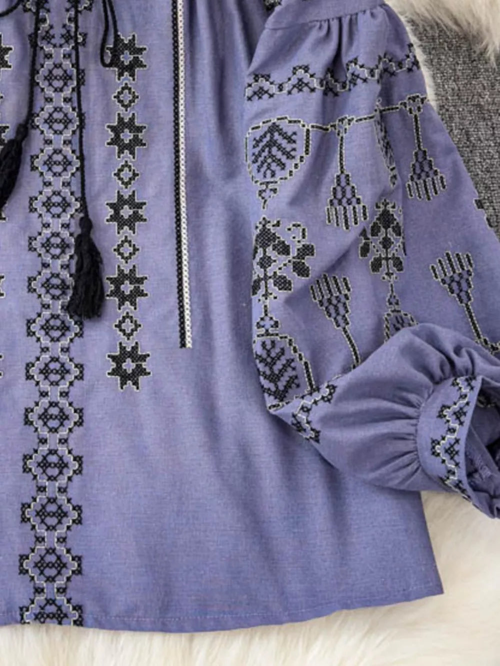 Purple embroidered tie neck blouse with tassels and puff sleeves.