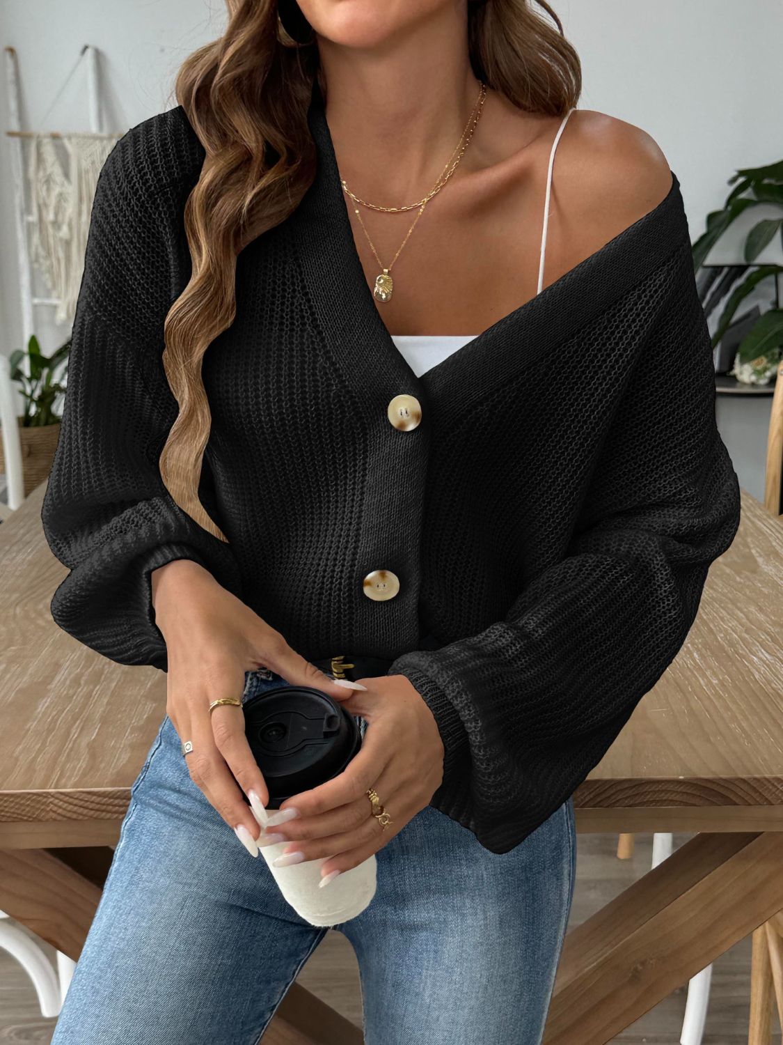 Black balloon sleeve button-down knit cardigan with tan buttons.