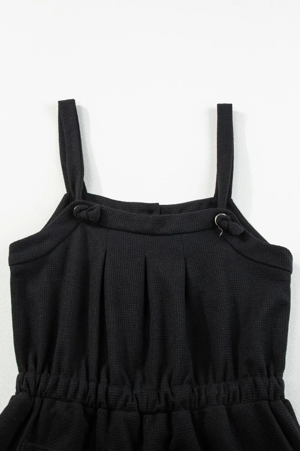 Black waffle knit jumpsuit with adjustable tie straps and elastic waist