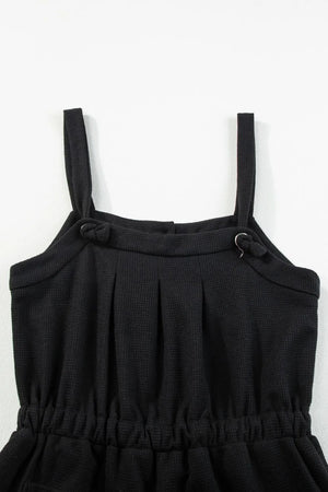 Black waffle knit jumpsuit with adjustable tie straps and elastic waist