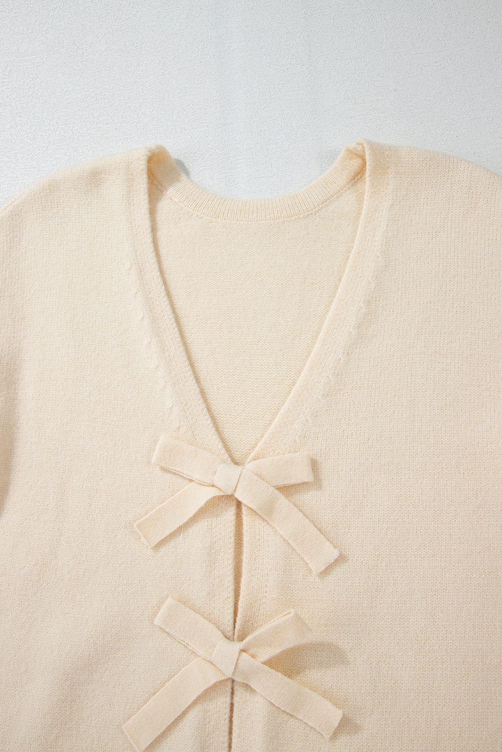 Ivory bouclé knit cardigan with tie-front bow details