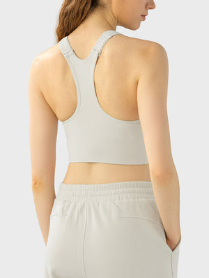 Zip-front racerback sports bra in ivory with adjustable straps.