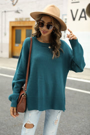 Turquoise knit pullover sweater with crewneck, long sleeves, and slit hem detail.