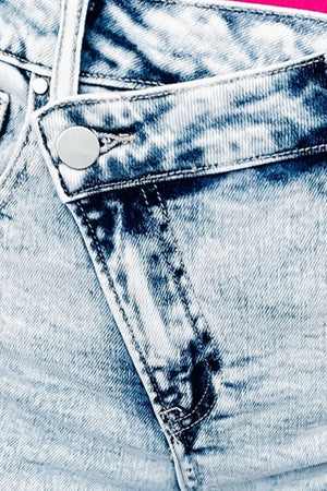 Light wash denim shorts with asymmetric waistband and button closure detail