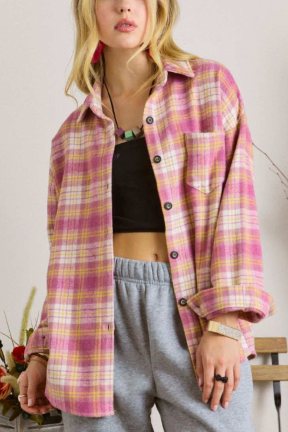 Oversized pink plaid flannel overshirt with button-down front and chest pocket.
