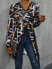 Black geometric asymmetric blouse with decorative buttons and wrap detail.
